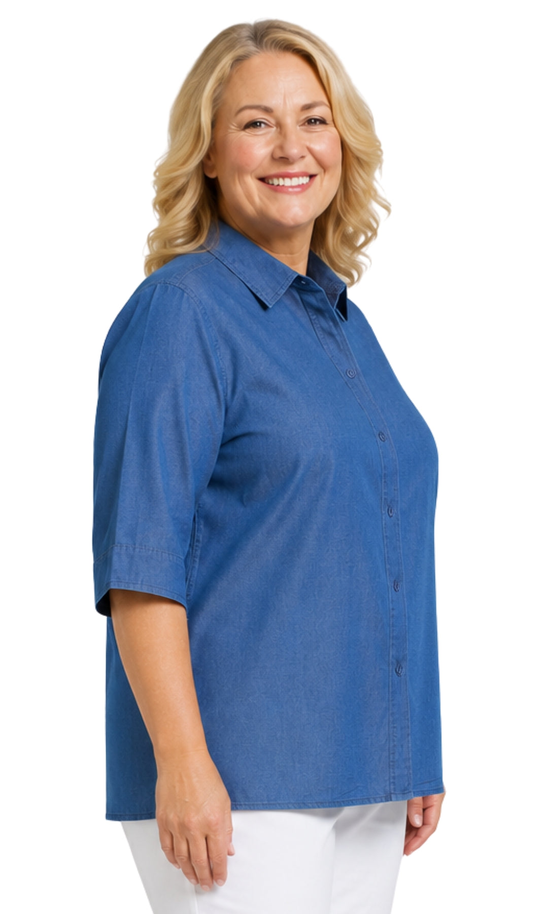 A smiling blonde woman wearing a blue short-sleeve button-up shirt and white pants, photographed against a plain white background.