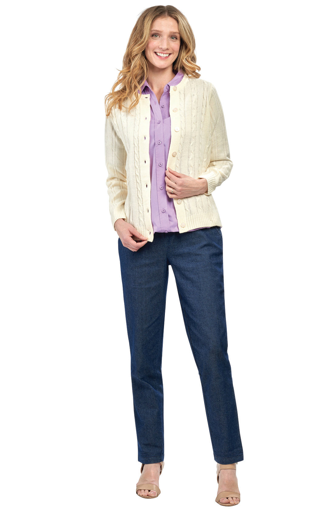 Woman wearing a light yellow cardigan over a purple shirt and blue pants on a white background