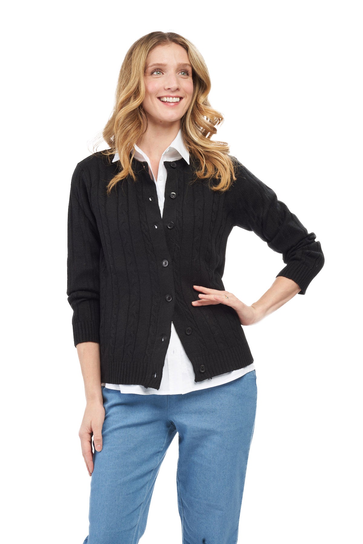 Woman wearing a black cardigan over a white shirt with blue pants on a white background