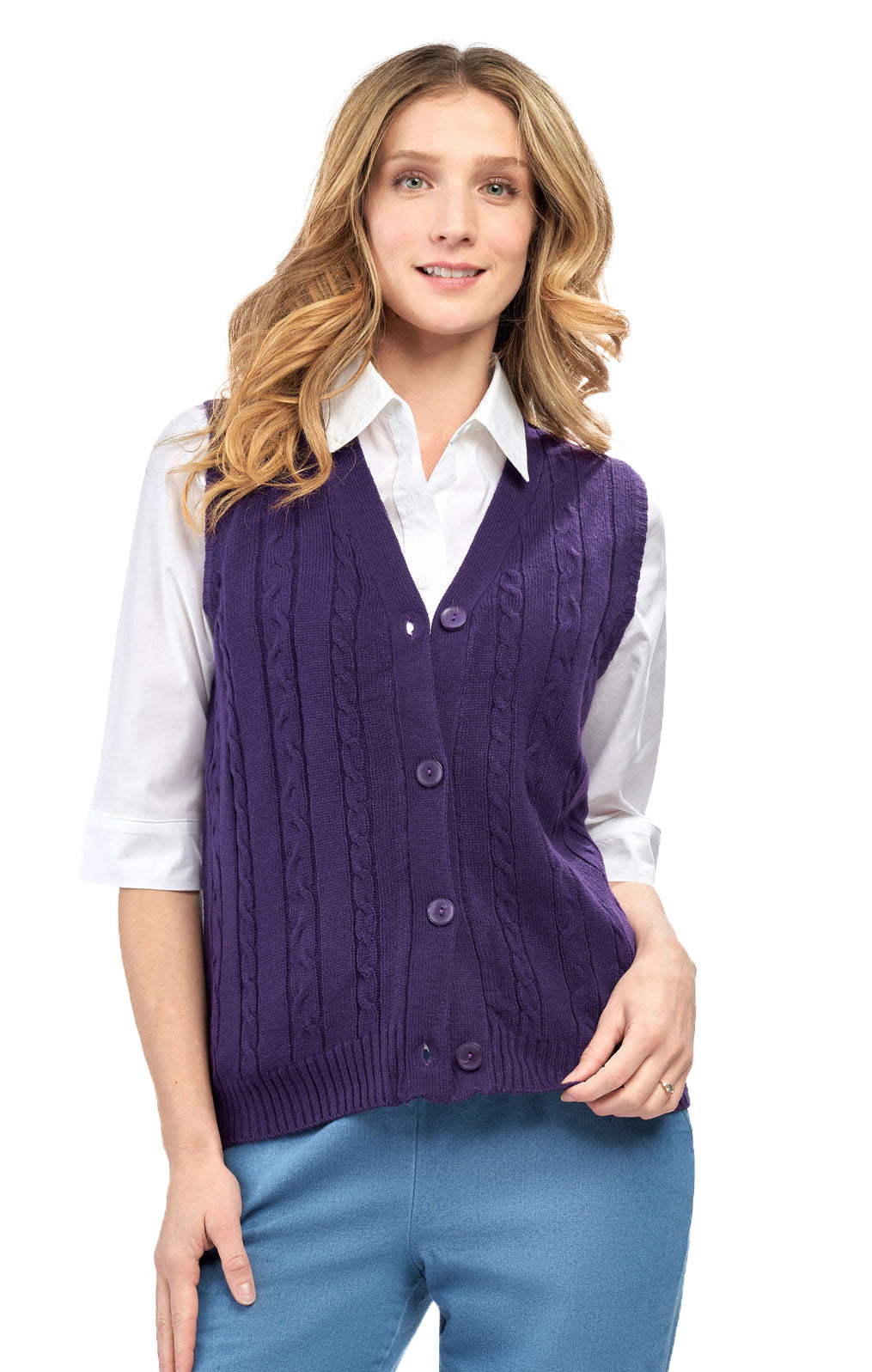Woman wearing a purple cardigan over a white shirt and blue pants on a white background